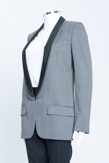 Grey wool tuxedo style jacket with triple elongated lapel, grosgrain detail and hook and eye fastening.